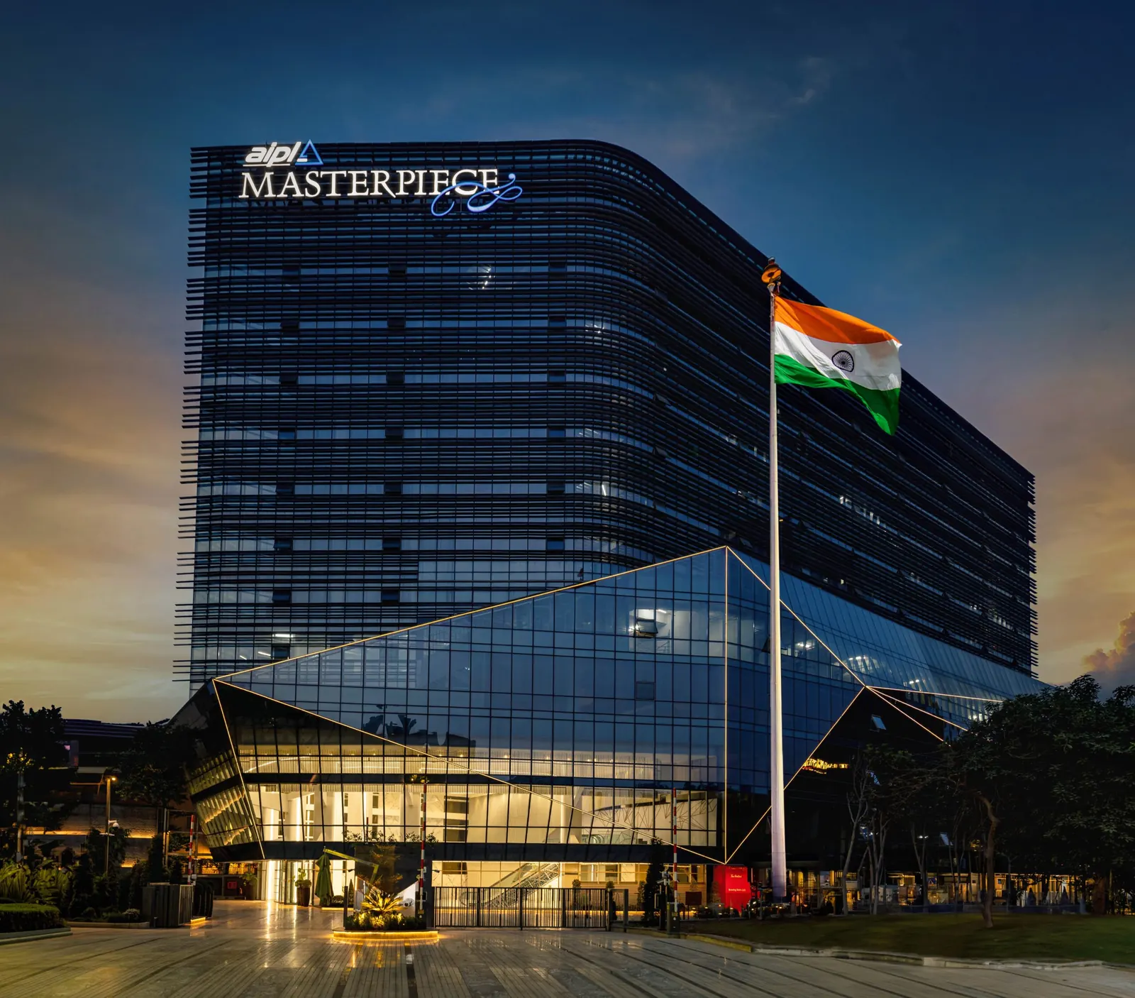 AIPL Masterpiece curved glass office building on Golf Course Road with the flag at the entrance