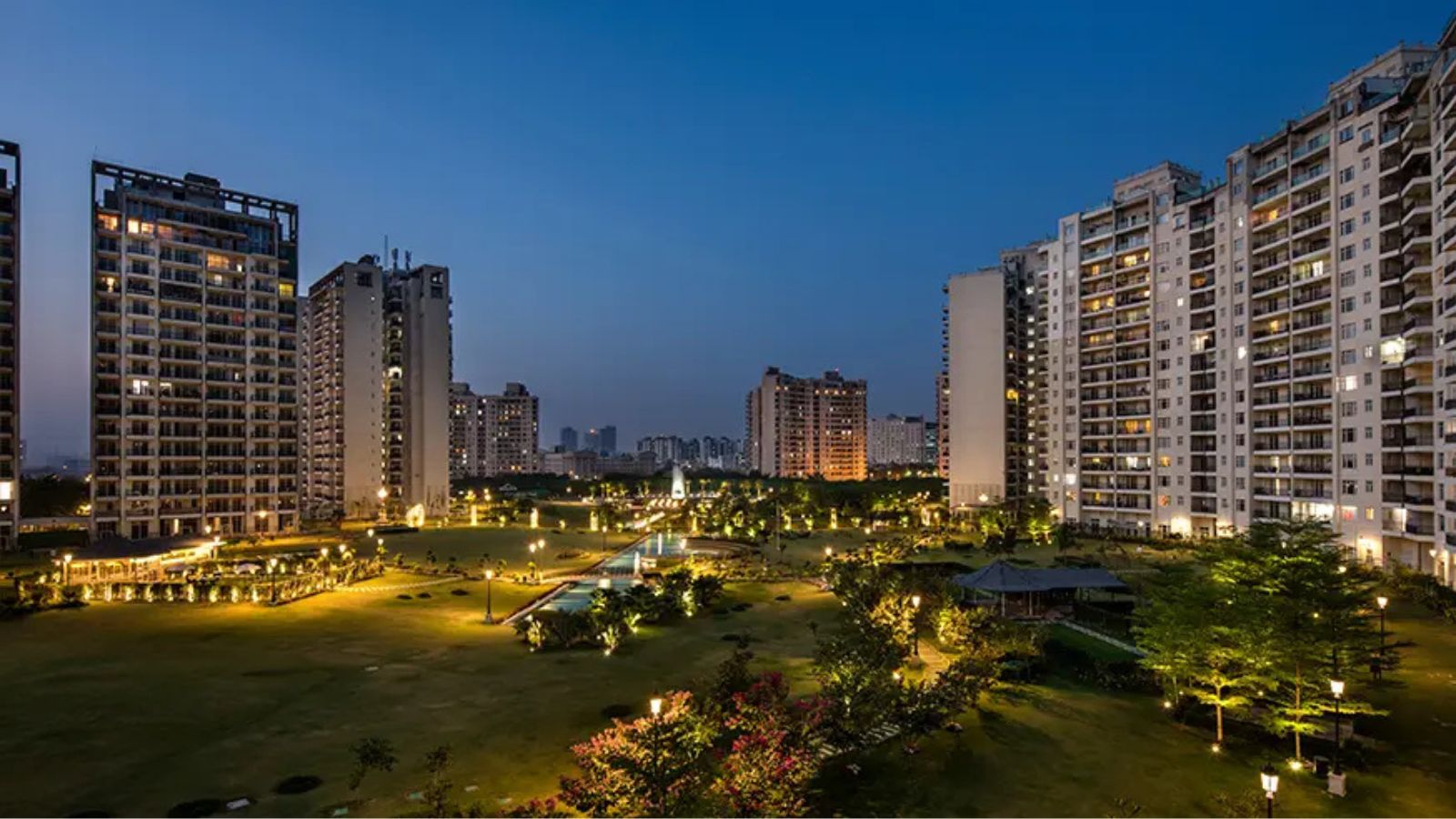 Central Park Resort Belgravia Residences towers around the illuminated central garden at dusk