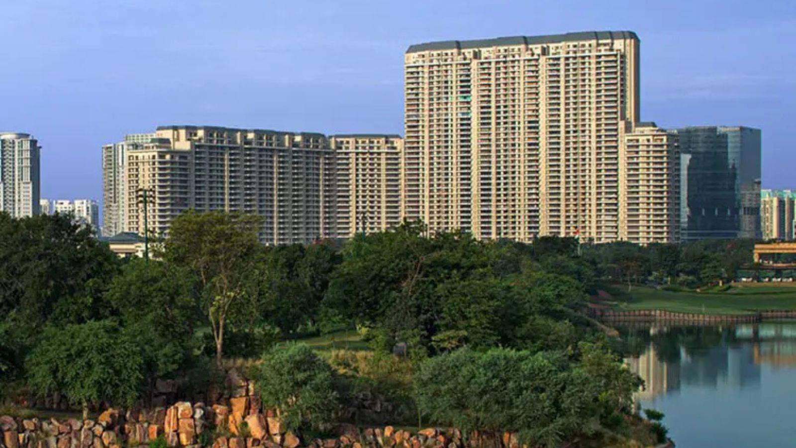 DLF The Camellias towers above the golf course lake and trees