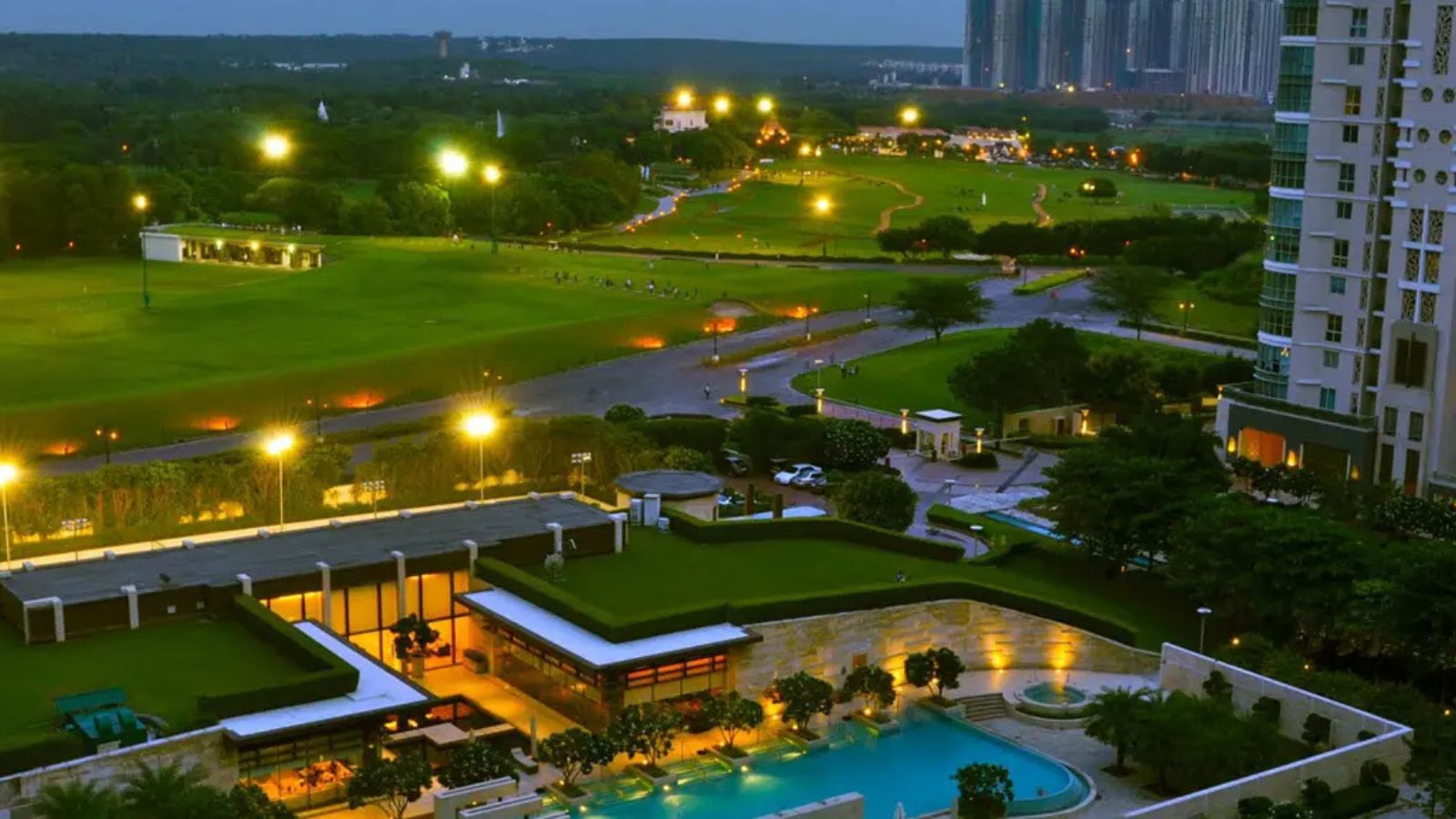 DLF The Aralias clubhouse and pool beside the golf course at dusk