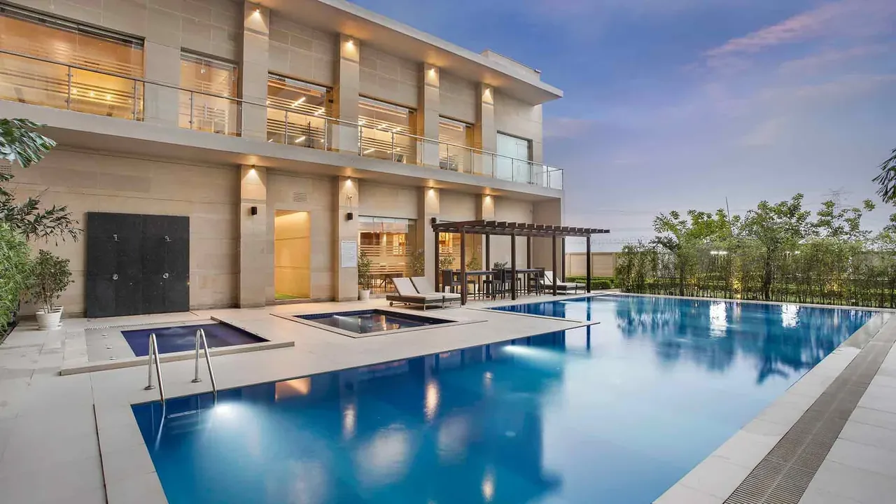 Adani M2K Oyster Grande clubhouse building with outdoor pool and jacuzzi, photo