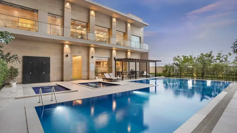 Adani M2K Oyster Grande clubhouse building with outdoor pool and jacuzzi, photo