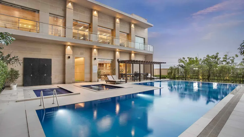 Adani M2K Oyster Grande clubhouse building with outdoor pool and jacuzzi, photo