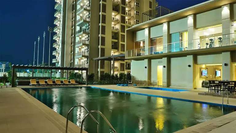 Adani M2K Oyster Grande lap pool beside the clubhouse at dusk, photo