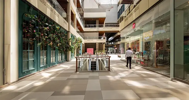 AIPL Joy Central internal retail street with planters and storefronts