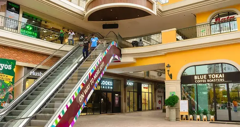 AIPL Joy Street escalators to the upper retail floor beside the Blue Tokai cafe
