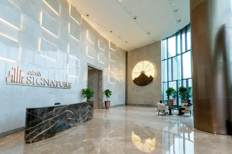 AIPL Signature lobby reception with the Signature sign and marble floor