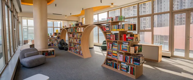 Ashiana Amarah reading room with arched bookshelves and floor-to-ceiling glass, developer photo