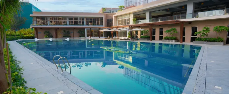 Ashiana Amarah swimming pool in front of the clubhouse terraces, developer photo