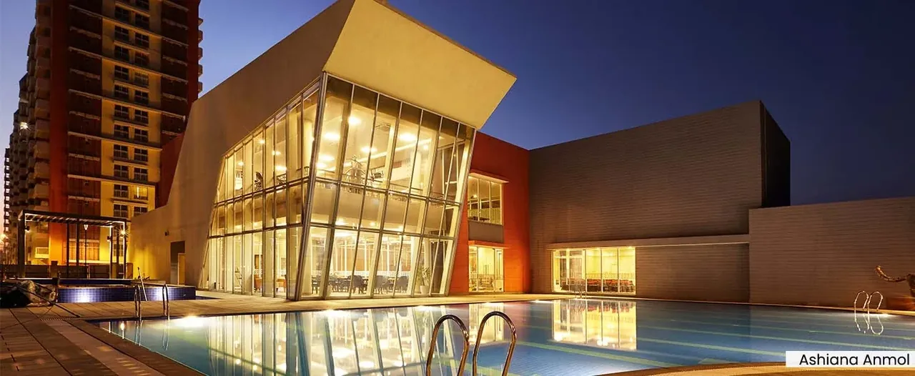Ashiana Anmol glass clubhouse beside the pool at night