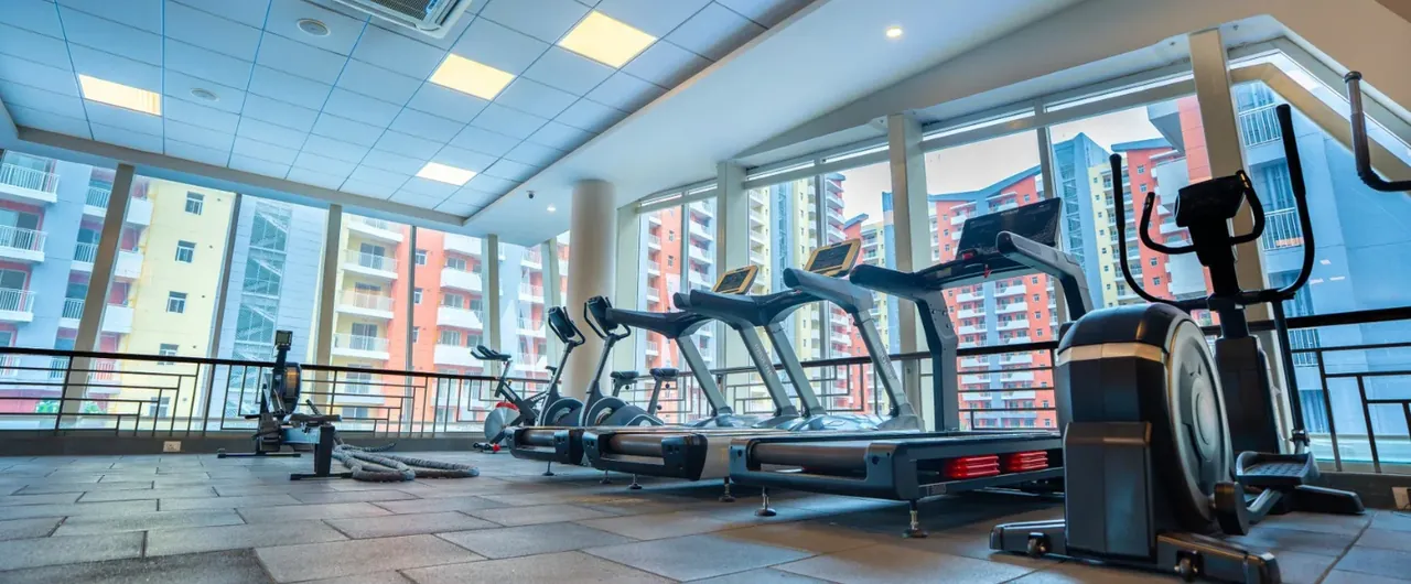 Ashiana Anmol gym with treadmills facing the windows