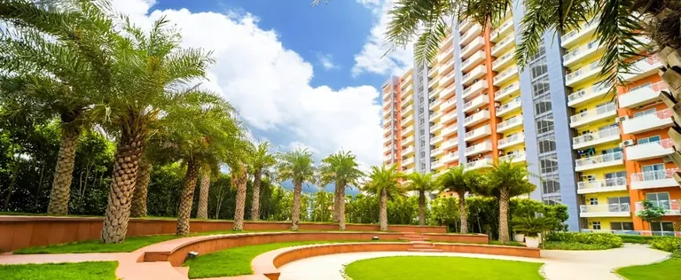 Ashiana Anmol palm garden and seating in front of a tower