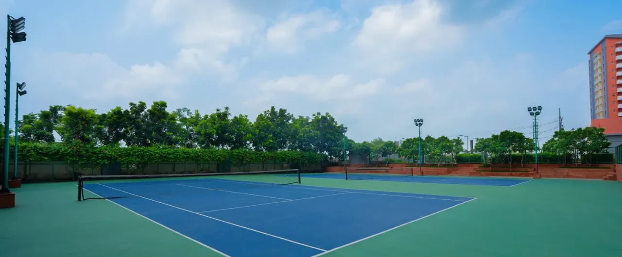 Ashiana Anmol synthetic tennis court with towers behind