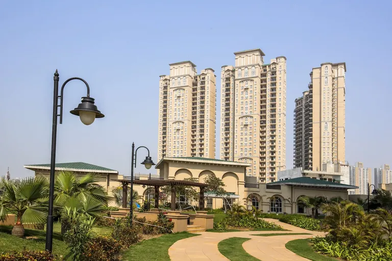 ATS Triumph arched clubhouse with lamp-lit garden path and towers behind, photo