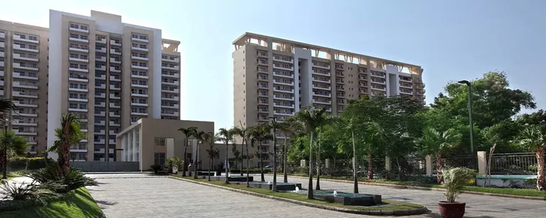 Bestech Park View Spa Next completed towers beyond the palm-lined entrance drive