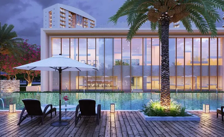 Chintels Serenity clubhouse and pool deck with palm tree at dusk, artist's impression