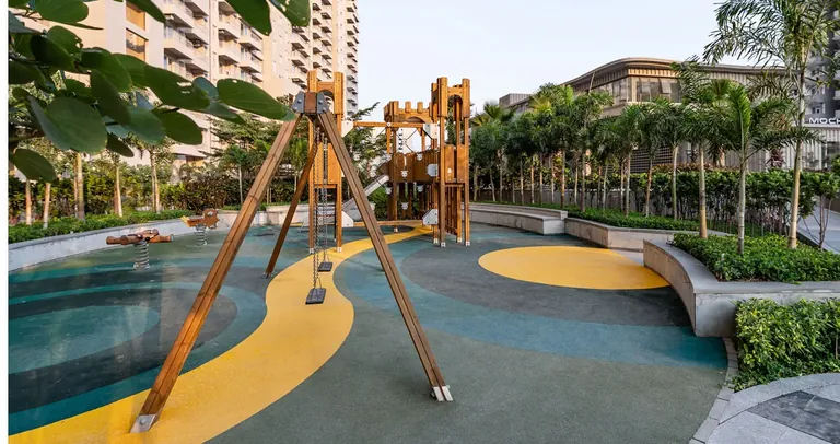 County The Center Court children's play area with timber swings and landscaped seating