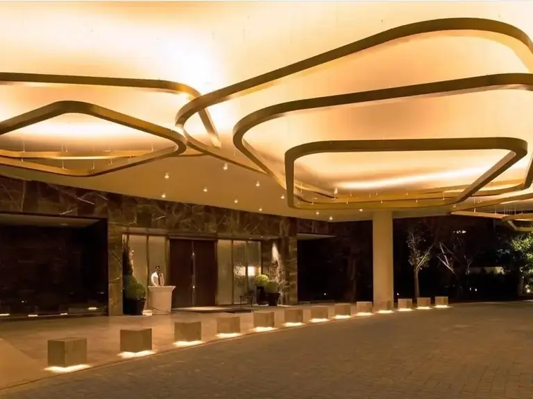 DLF The Camellias tower entrance lobby with its sculpted lit ceiling at night