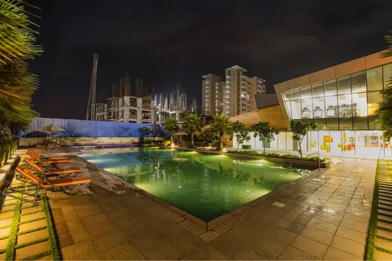 Eldeco Accolade pool and sun loungers at night
