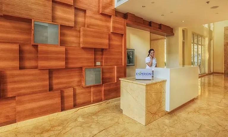 Experion The Heartsong clubhouse reception with timber-panelled wall, actual photo