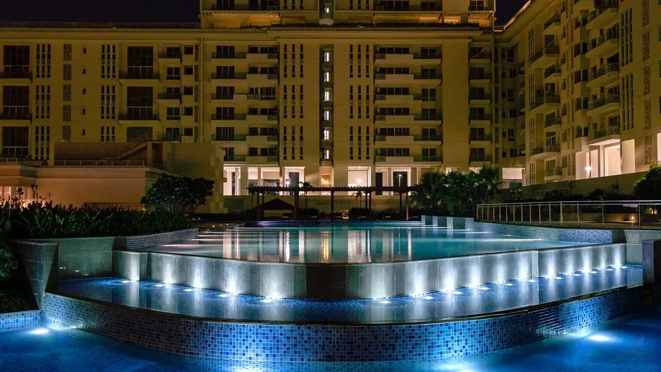 Experion Windchants swimming pool lit up at night in front of the villaments, actual photo