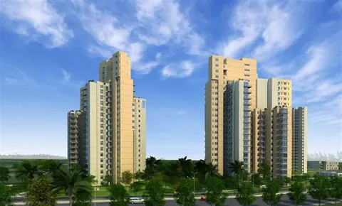 Ireo Uptown residential towers above tree tops under a blue sky, artist's impression
