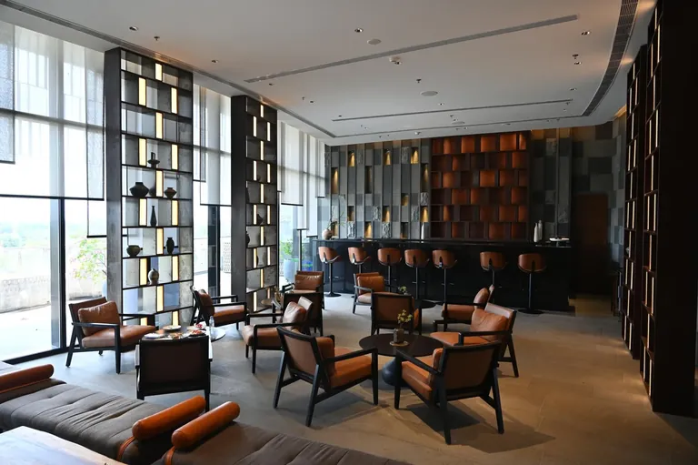 Krisumi Waterfall Residences clubhouse bar lounge beside full-height windows, actual photo