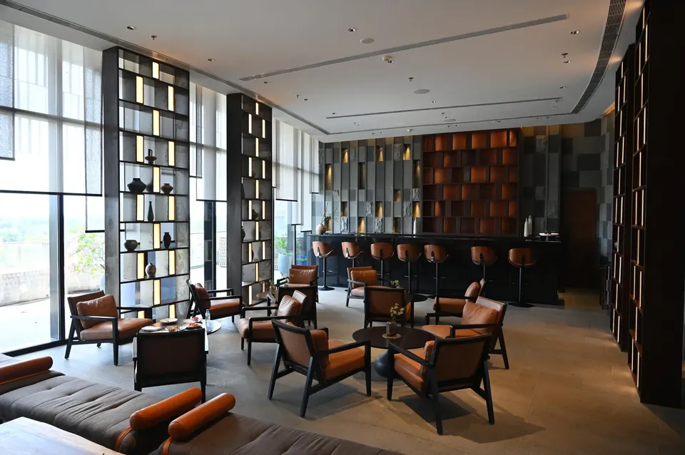 Krisumi Waterfall Residences clubhouse bar lounge beside full-height windows, actual photo