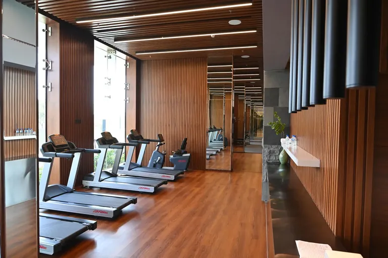 Krisumi Waterfall Residences clubhouse gym with treadmills and timber floor, actual photo