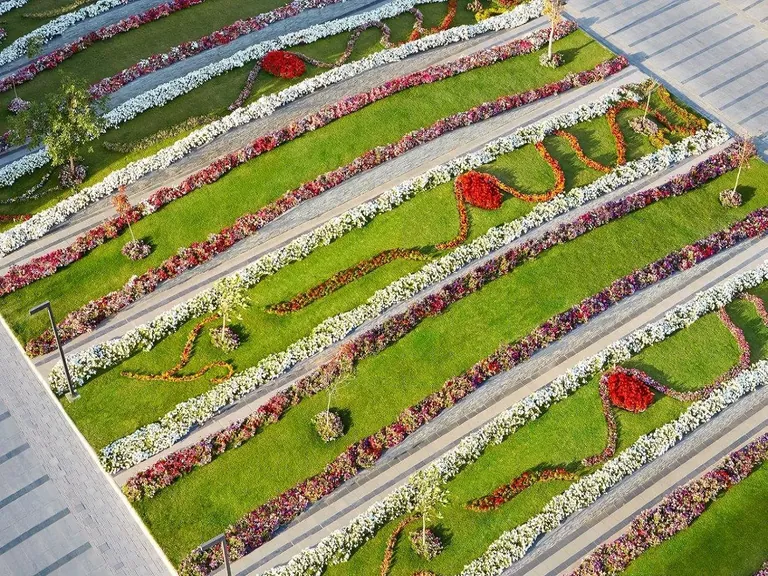 M3M Golfestate terraced lawns planted with bands of flower beds, seen from above