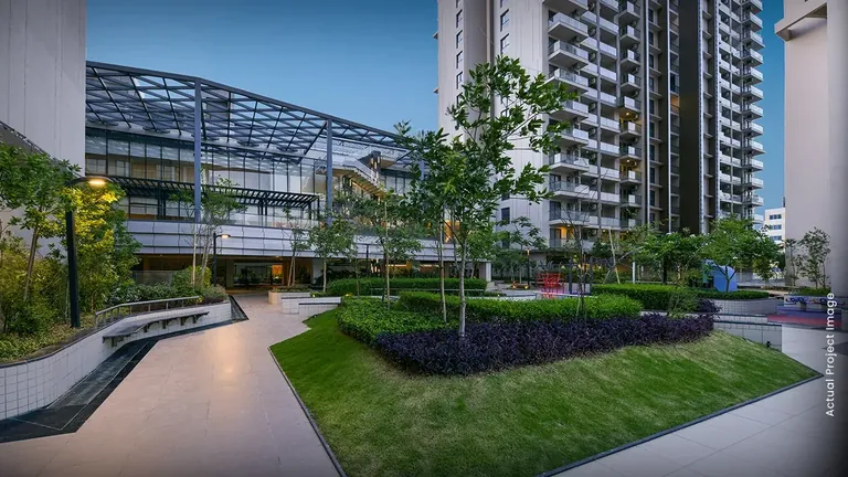 M3M Heights landscaped courtyard with lawns and walkways at the foot of the towers