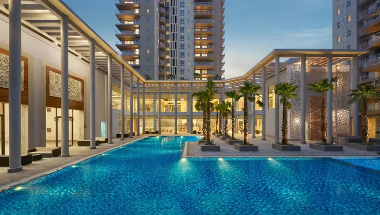 Puri Diplomatic Greens clubhouse pool deck with the towers behind