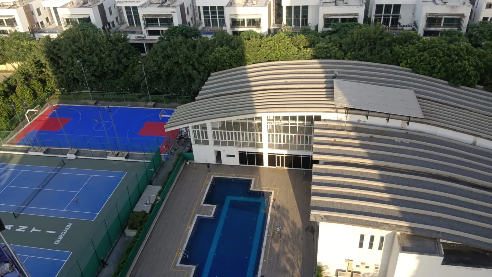 Tata Primanti clubhouse pool and sports courts seen from a tower
