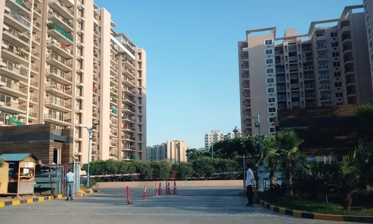 Tulip Purple entrance gate with security cabin and residential towers on both sides